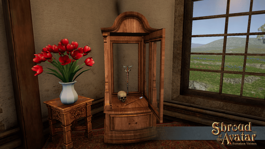 A tall wooden case with glass on all four sides and a drawer underneath sits in the corner of a plastered room next to a vase of red tulips and a large picture window looking out into meadow.  The case holds two wands and a skull and the door is open for further adjustments or additions.