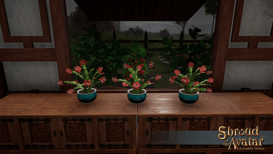 Three coral-flowered cacti in aqua pots sit in front of a window looking out on a cold and stormy garden.