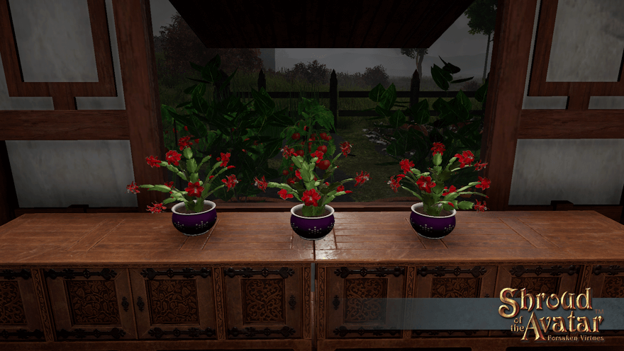 Three red-flowered cacti in purple pots sit in front of a window looking out on a cold and stormy garden.