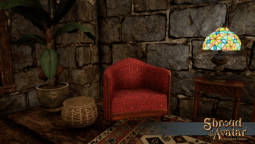 A small round basket with a lid sits next to a red jacquard chair in a stone room. Snacks? Knitting? Kittens? Adders? Only one way to find out!