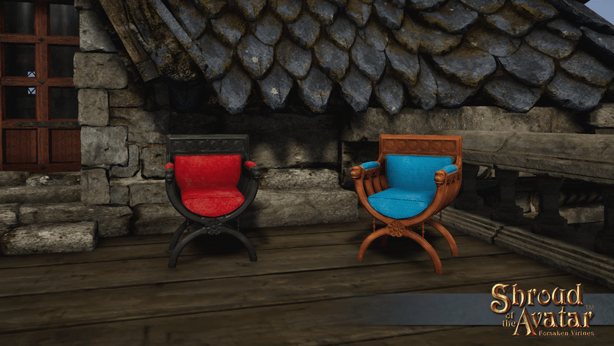 A black wood curule armchair with red cushions and a brown wood curule armchair with sky blue cushions sit on the terrace of a stone house.