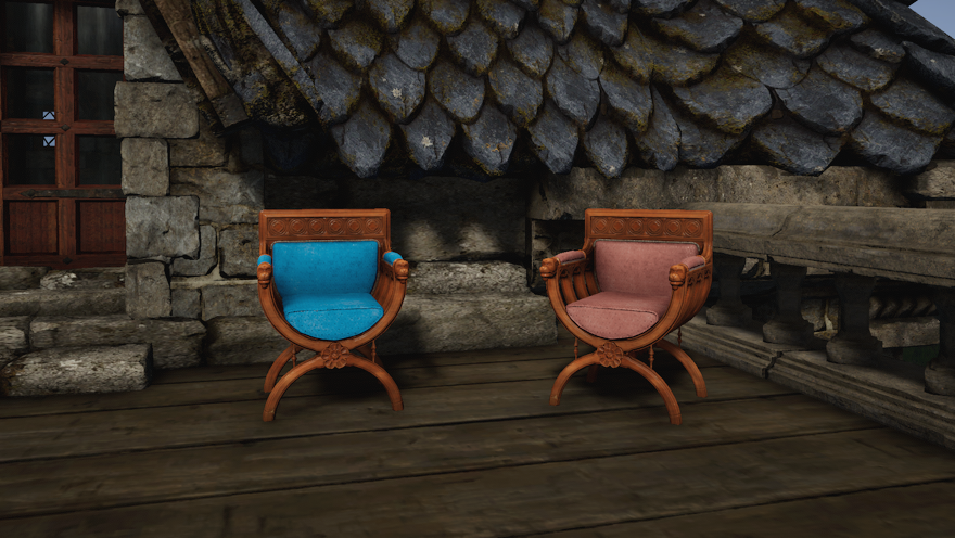 Two brown wood curule armchairs, one with sky blue cushions and one with dyed dark pink cushions, sit on the terrace of a stone house.