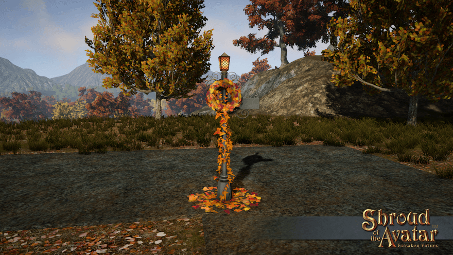 Next to a fallow granite road in Harvest, a light metal street lamp and sign holds a red and gold autumn leaf wreath.  Leaves also climb the base and litter the ground around it.